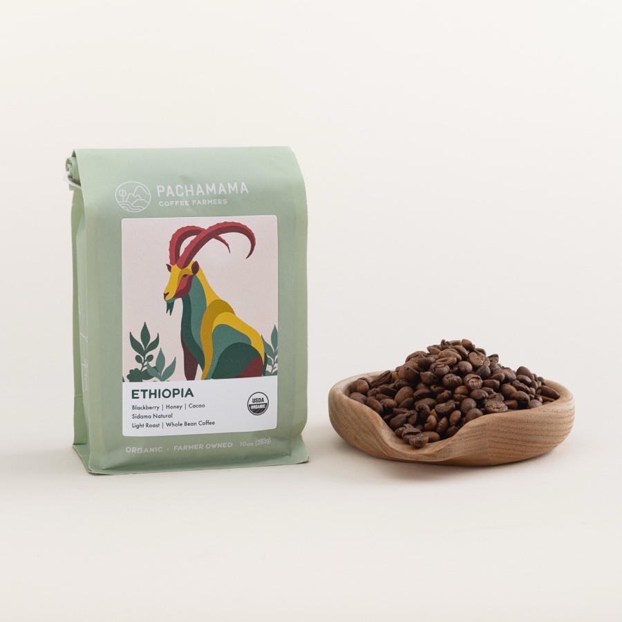 A bag of Ethiopia Sidama coffee beside a wooden dish of roasted beans, on a plain background